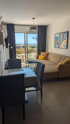 a living room with a couch and a table at Kama Lifestyle Modern apt with sea view in Protaras