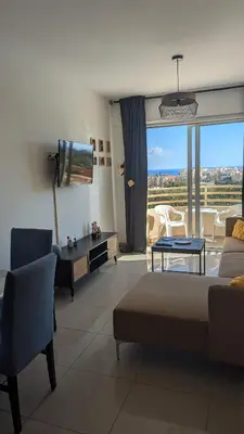 a living room with a couch and a tv at Kama Lifestyle Modern apt with sea view in Protaras