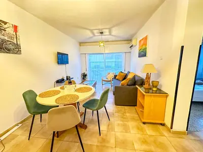 a living room with a table and chairs and a couch at Sea and Lake Breeze 1BR Apt in Larnaka