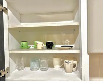 a shelf with cups and other items on it at Sea and Lake Breeze 1BR Apt in Larnaka