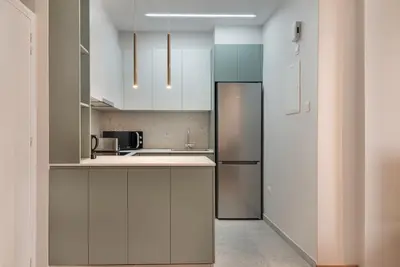 a kitchen with white cabinets and a refrigerator at Phaedrus Living Larnaca Tsimintia Retreat in Larnaka