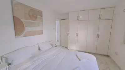 a white bedroom with a large bed and white cabinets at STAY Chrisoula Beach Garden in Voroklini