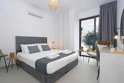 a bedroom with a bed and a table and chairs at Villa Vitalia - 3 En-suite Beds with Private Pool in Paralimni