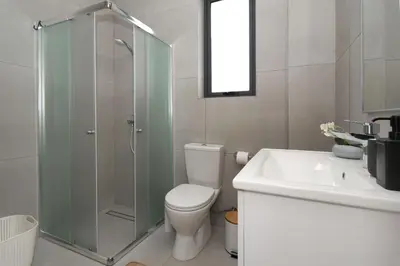 a bathroom with a shower and a toilet and a sink at Villa Vitalia - 3 En-suite Beds with Private Pool in Paralimni