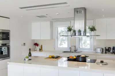 a kitchen with white cabinets and a counter top at Protaras Sirina Seafront Paradise in Protaras