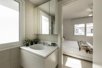a bathroom with a sink and a mirror and a bed at Protaras Sirina Seafront Paradise in Protaras