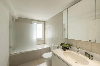 a bathroom with a sink and a toilet and a mirror at Protaras Sirina Seafront Paradise in Protaras