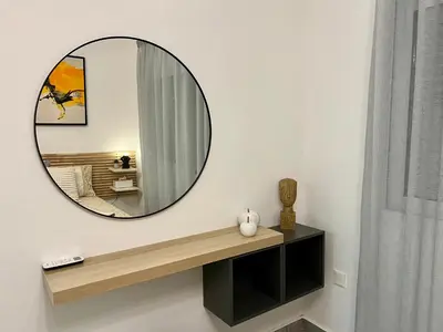 a round mirror on a wall in a room at FatCow Beach Apartment in Larnaka