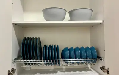 a closet with blue chairs and white bowls on shelves at FatCow Beach Apartment in Larnaka