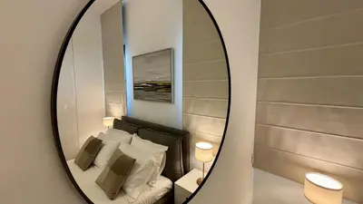 a mirror in a room with a bed with pillows at Oxford House Apt by TrulyCyprus in Limassol