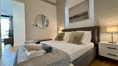 a bedroom with a large bed with a mirror at Oxford House Apt by TrulyCyprus in Limassol