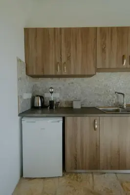 a kitchen with a white refrigerator and wooden cabinets at Dipaton House in Vasa 1 in Limassol