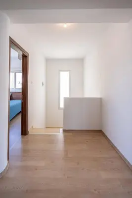 an empty room with white walls and a wooden floor at Hubstay - Blue Harmony Villa in Protaras - 5 min Walk to the Beach in Paralimni