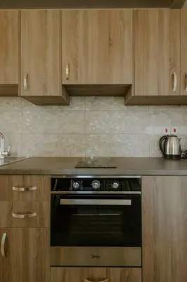 a kitchen with a black oven and wooden cabinets at Dipaton House in Vasa 2 in Vasa Kilaniou