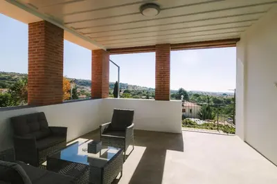 a living room with chairs and a table on a balcony at Dipaton House in Vasa 2 in Vasa Kilaniou