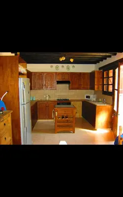 a kitchen with wooden cabinets and a white refrigerator at Clover Cottage in Limassol