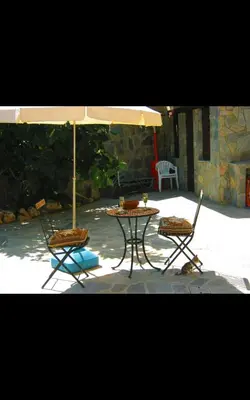 a table and chairs with an umbrella on a patio at Clover Cottage in Limassol