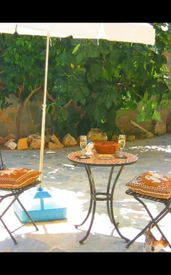 a table with two chairs and an umbrella at Clover Cottage in Limassol