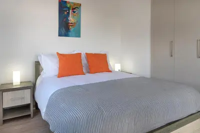 a bedroom with a large bed with orange pillows at Phaedrus Living Larnaca Harbour Heights in Larnaka