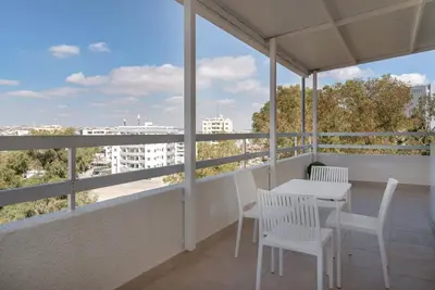 a balcony with a table and chairs and a view at Phaedrus Living Larnaca Harbour Heights in Larnaka