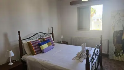 a bedroom with a bed with white sheets and a window at STAY Uptown Apartment in Engomi