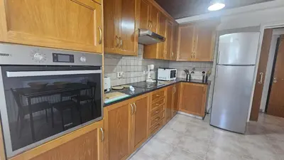 a kitchen with wooden cabinets and a stainless steel refrigerator at STAY Uptown Apartment in Engomi