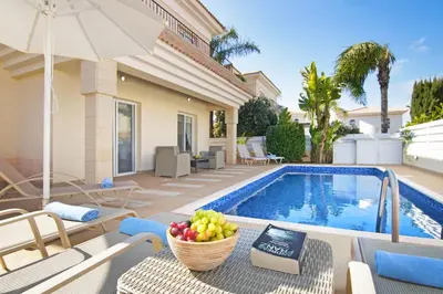 a villa with a pool and a table with a bowl of fruit at Villa Alyson in Paralimni