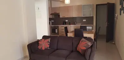 a living room with a couch and a kitchen at Mazotos Panoramic Village in Mazotos