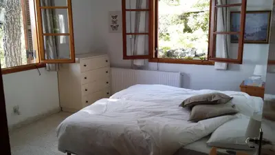 a bedroom with a white bed and two windows at Villa in Moniatis in Moniatis
