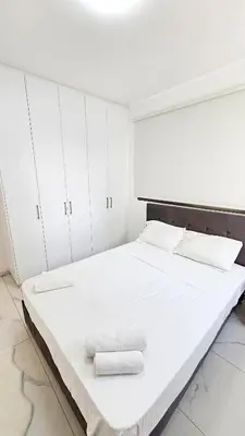 a white bedroom with a large bed with towels on it at Modern Wellness Escape Apartment with Optional Health Transformation Retreat in Larnaka