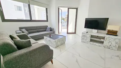 a living room with two couches and a flat screen tv at Modern Wellness Escape Apartment with Optional Health Transformation Retreat in Larnaka
