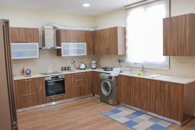 a kitchen with wooden cabinets and a washing machine at Marios Villa in Larnaka