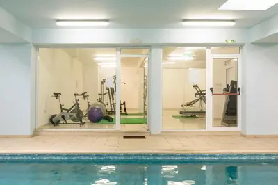 a gym with a swimming pool and exercise equipment at Obv 5201 in Pyla