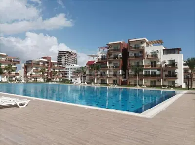 a swimming pool in front of some apartment buildings at The Aqua Marine Flat in Iskele