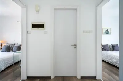 a bedroom with two doors leading to a bed at Corali Villa in Pernera Protaras in Paralimni