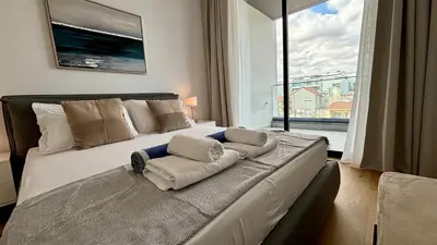 a bedroom with a large bed with a large window at Bali Residence Apt by TrulyCyprus in Limassol
