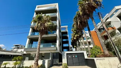 an apartment building with palm trees in front of it at Bali Residence Apt by TrulyCyprus in Limassol