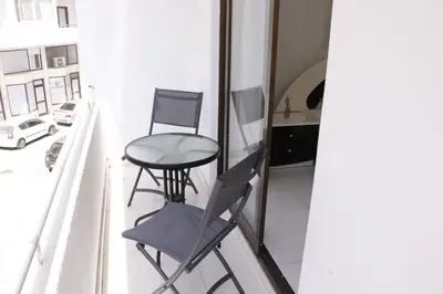 two chairs and a table on a balcony at Spacious Apartment, NEAR PINIKOUDES BEACH in Larnaka