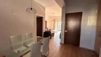 a living room with a table and chairs in a room at Bougainvillea in Nicosia