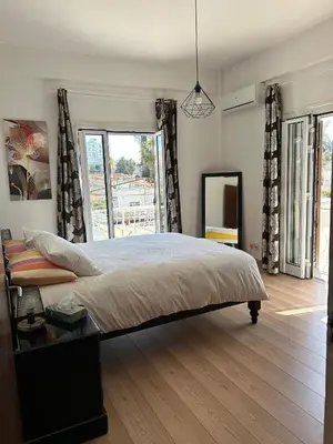 a bedroom with a large bed and a mirror at Bougainvillea in Nicosia