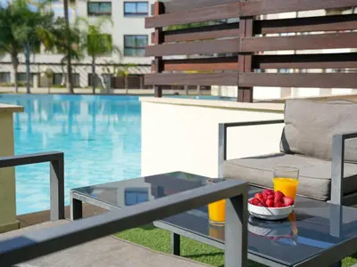 a table with a chair and a glass of orange juice at Aqua House Valentino in Limassol