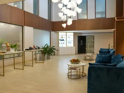 a lobby with blue couches and tables and windows at Aqua House Valentino in Limassol