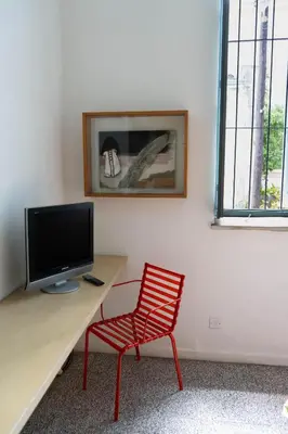 a room with a desk with a television and a red chair at ResArt Traditional House in Nicosia