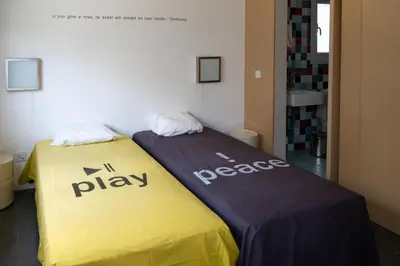 a bed in a room with a yellow and purple blanket at ResArt Traditional House in Nicosia