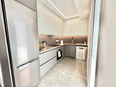 a kitchen with white cabinets and a refrigerator at V-Premium Brand New Central flat in Limassol