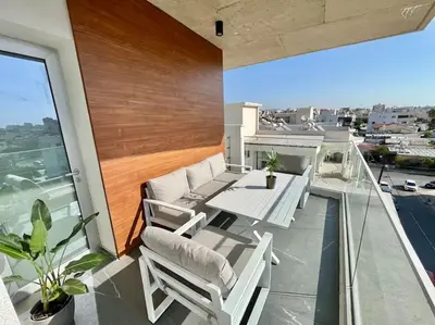 a balcony with a table and chairs on a roof at V-Premium Brand New Central flat in Limassol