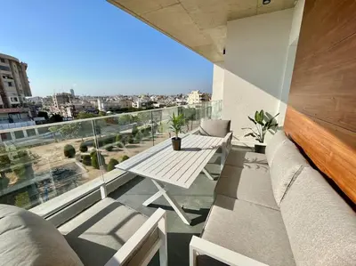 a balcony with a table and a view of the city at V-Premium Brand New Central flat in Limassol