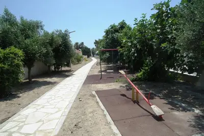 a road with trees and a sidewalk with a red hose at Villa Anthea-beach-private pool in Meneou