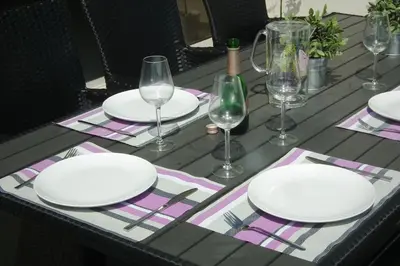 a table with white plates and wine glasses on it at Villa Anthea-beach-private pool in Meneou