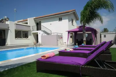 a villa with a swimming pool and purple loungers at Villa Anthea-beach-private pool in Meneou